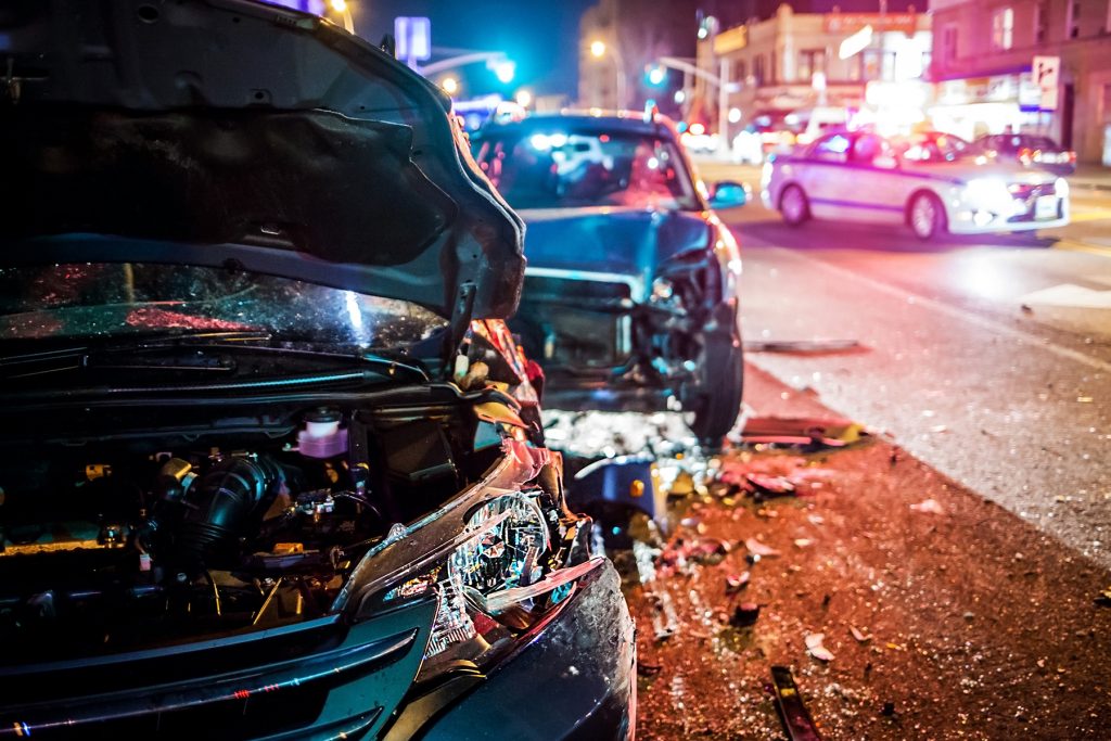 Automobile accident with front car hood up and smashed by car in the back whose front end is smashed