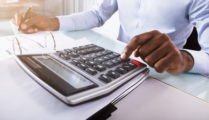 man sitting at a desk using calculator to value a personal injury claim in rhode island